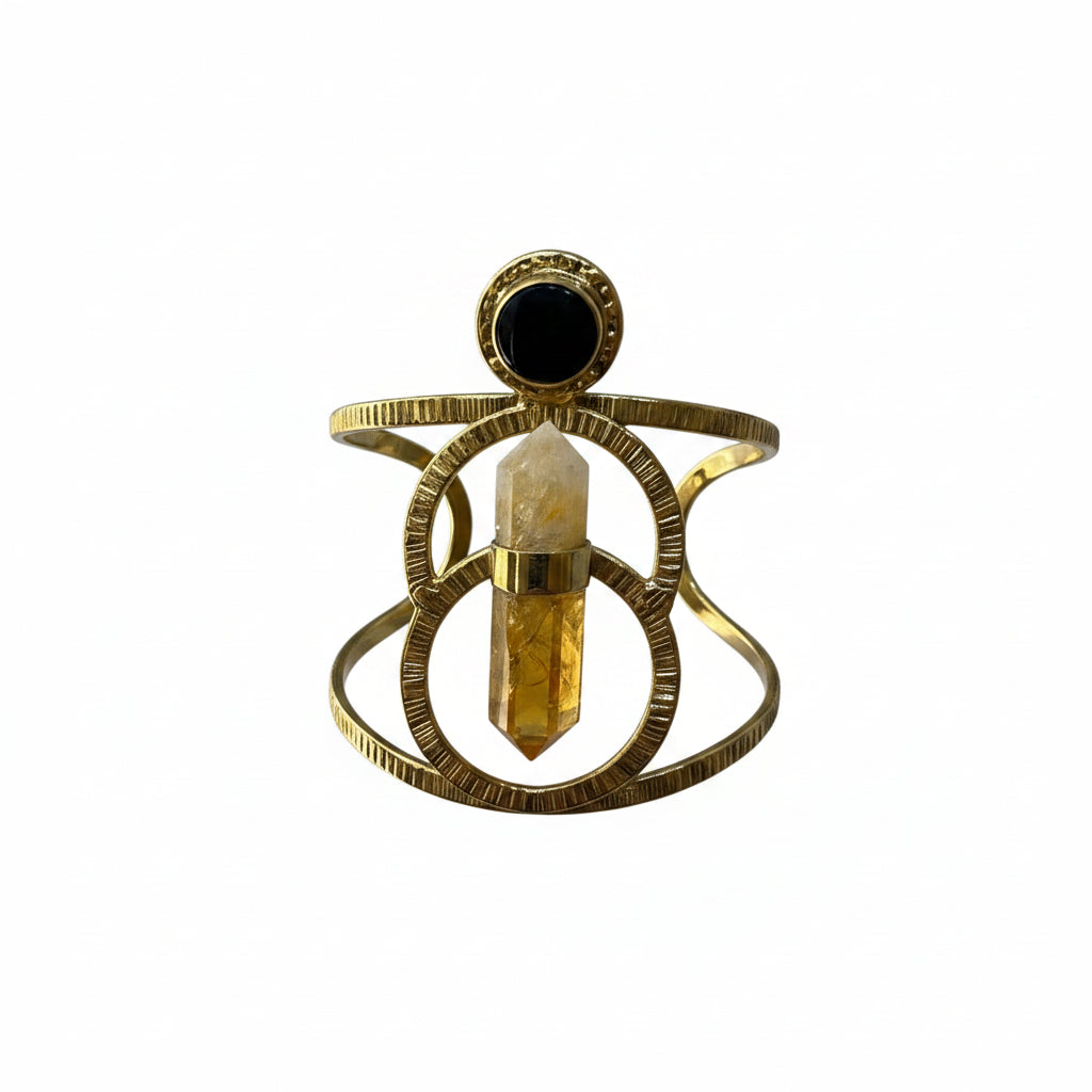 Gold ring with a central gemstone held against a plain white background