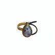 Hand holding a gold bracelet with a stone and black hair tie against a light background